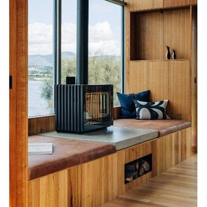 Castworks Hergóm Glance MV freestanding wood fireplace with sleek design and glass door, ideal for modern living spaces.