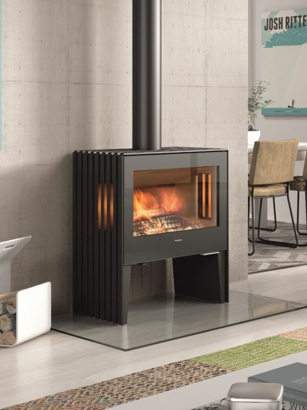 Castworks Hergóm Glance L wood fireplace with sleek black metal exterior and large glass front for viewing the fire.