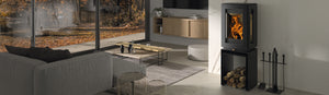 Castworks Hergóm Glow wood fireplace with a sleek design and glass front, showcasing a cozy fire burning inside.