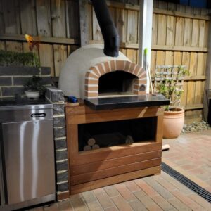 HVH70 Real Brick Preassembled Pizza Oven by HVH Pizza Ovens, showing the brick exterior and cooking chamber inside.